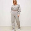 Women's active wear tracksuit. Close-up on textured fabric, vibrant stitching, multiple logo placements. Sporty chic design,