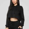 Women's black cropped tracksuit. Sleek, form-fitting design. Ribbed texture on the crop top and high-waisted bottoms. Visible