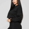 Women's black cropped tracksuit. Sleek, form-fitting design. Ribbed texture on the crop top and high-waisted bottoms. Visible