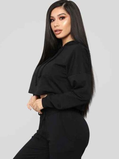 Women's black cropped tracksuit. Sleek, form-fitting design. Ribbed texture on the crop top and high-waisted bottoms. Visible