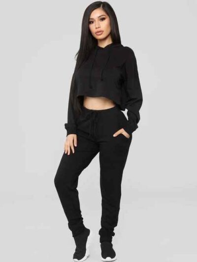 Women's black cropped tracksuit. Sleek, form-fitting design. Ribbed texture on the crop top and high-waisted bottoms. Visible