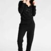 Women's lace-up tracksuit. Close-up shows soft, textured fabric. Dark grey with subtle stitch detailing. Sporty two-piece set