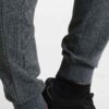 Slim-fit women's tracksuit in soft cotton. Close-up shows fine stitching & comfortable ribbed cuffs. Athletic style, perfect