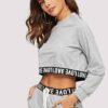 Woman's cropped sweatsuit, light cotton. Short sleeves, high-waisted bottoms. Premium stitching visible. Designed for style a