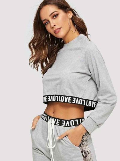 Woman's cropped sweatsuit, light cotton. Short sleeves, high-waisted bottoms. Premium stitching visible. Designed for style a