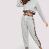 Woman's cropped sweatsuit, light cotton. Short sleeves, high-waisted bottoms. Premium stitching visible. Designed for style a