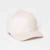 Close-up of a customizable twill cap. Visible stitching details, slightly distressed look, neutral tone. Garment is soft and
