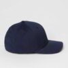 Close-up of a customizable twill cap. Visible stitching details, slightly distressed look, neutral tone. Garment is soft and