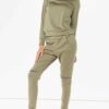 Crewneck sweatsuit with bust zipper. Soft, plush fabric, visible stitching. Custom lounge set, likely pastel or neutral tone.