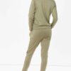 Crewneck sweatsuit with bust zipper. Soft, plush fabric, visible stitching. Custom lounge set, likely pastel or neutral tone.